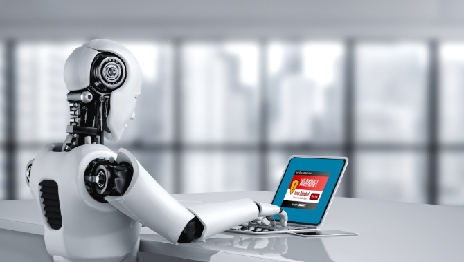 A robot using a laptop with a warning alert on the computer screen