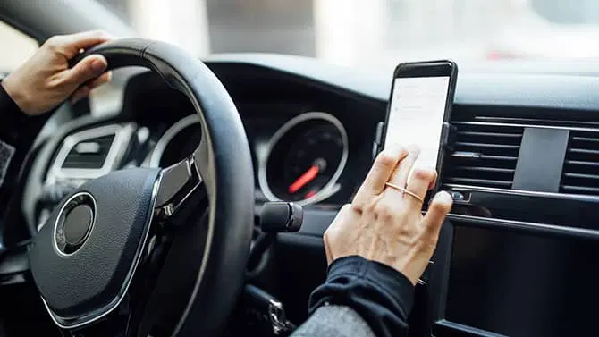 Eine Frau, die ihr Telefon im Auto benutzt, um nach ungesicherten WLAN-Netzwerken zu suchen