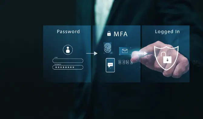 A man using his computer and phone for multi-factor authentication to access his emails.