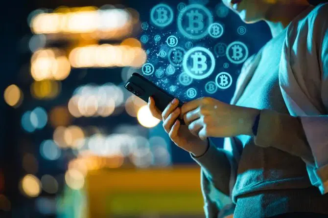 Frau schützt ihre Krypto-Coins vor einem Hackingversuch am Telefon.