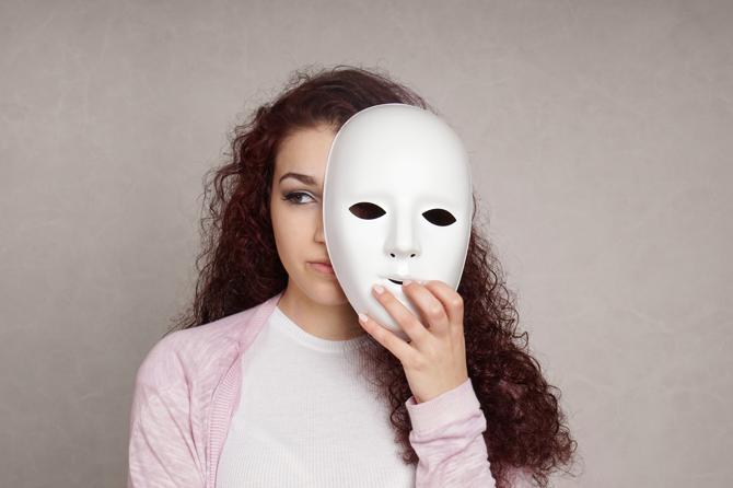 a woman looking out from behind a white mask