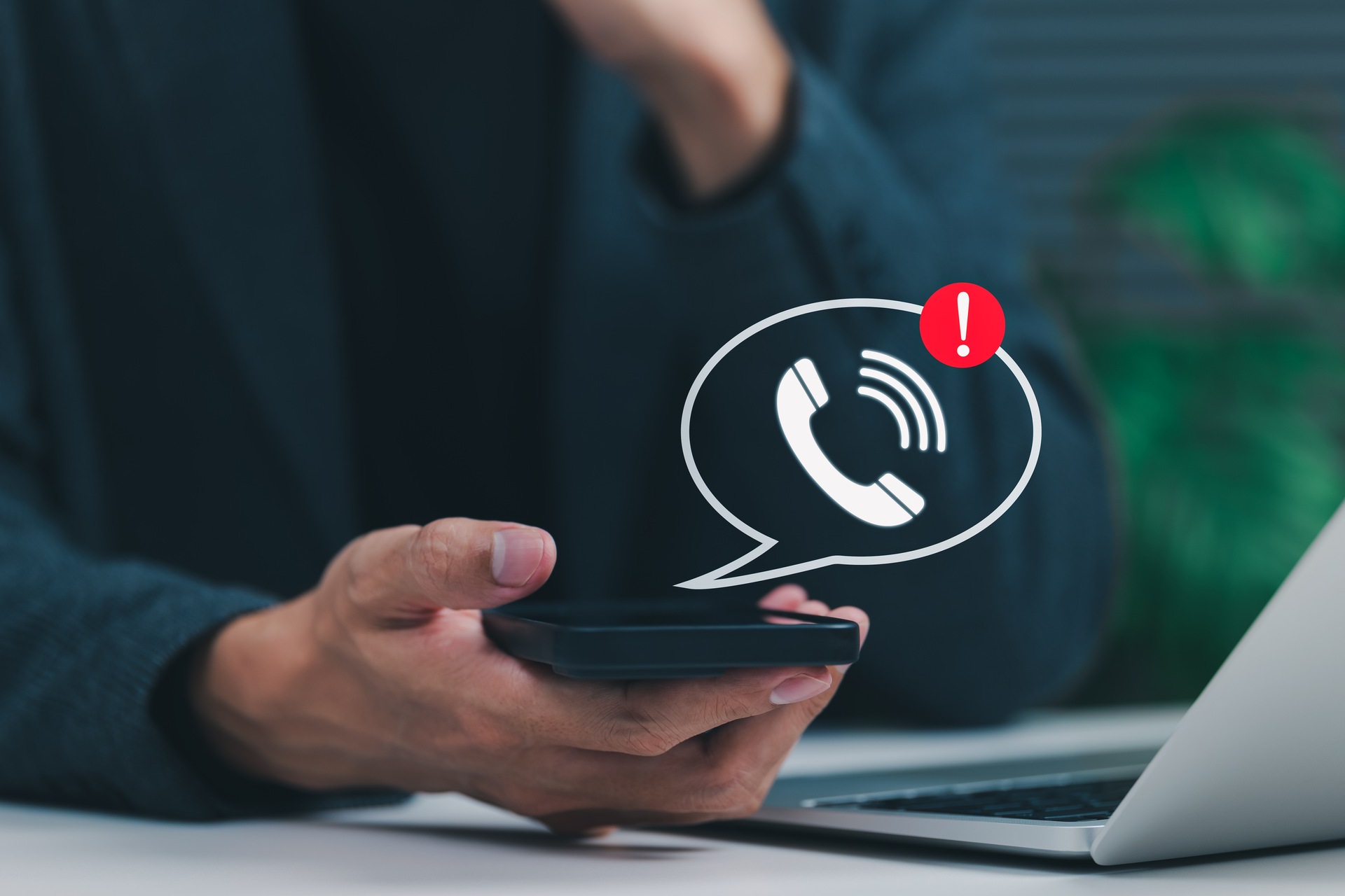 Person holding a smartphone and looking at a suspicious unknown-number text message