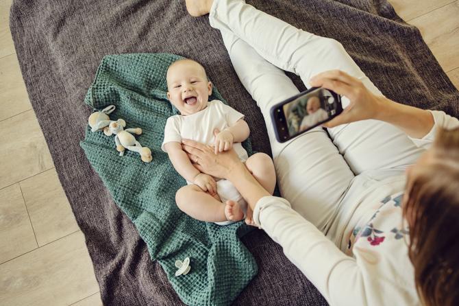 A mother practises sharenting by posting an image of her baby on social media