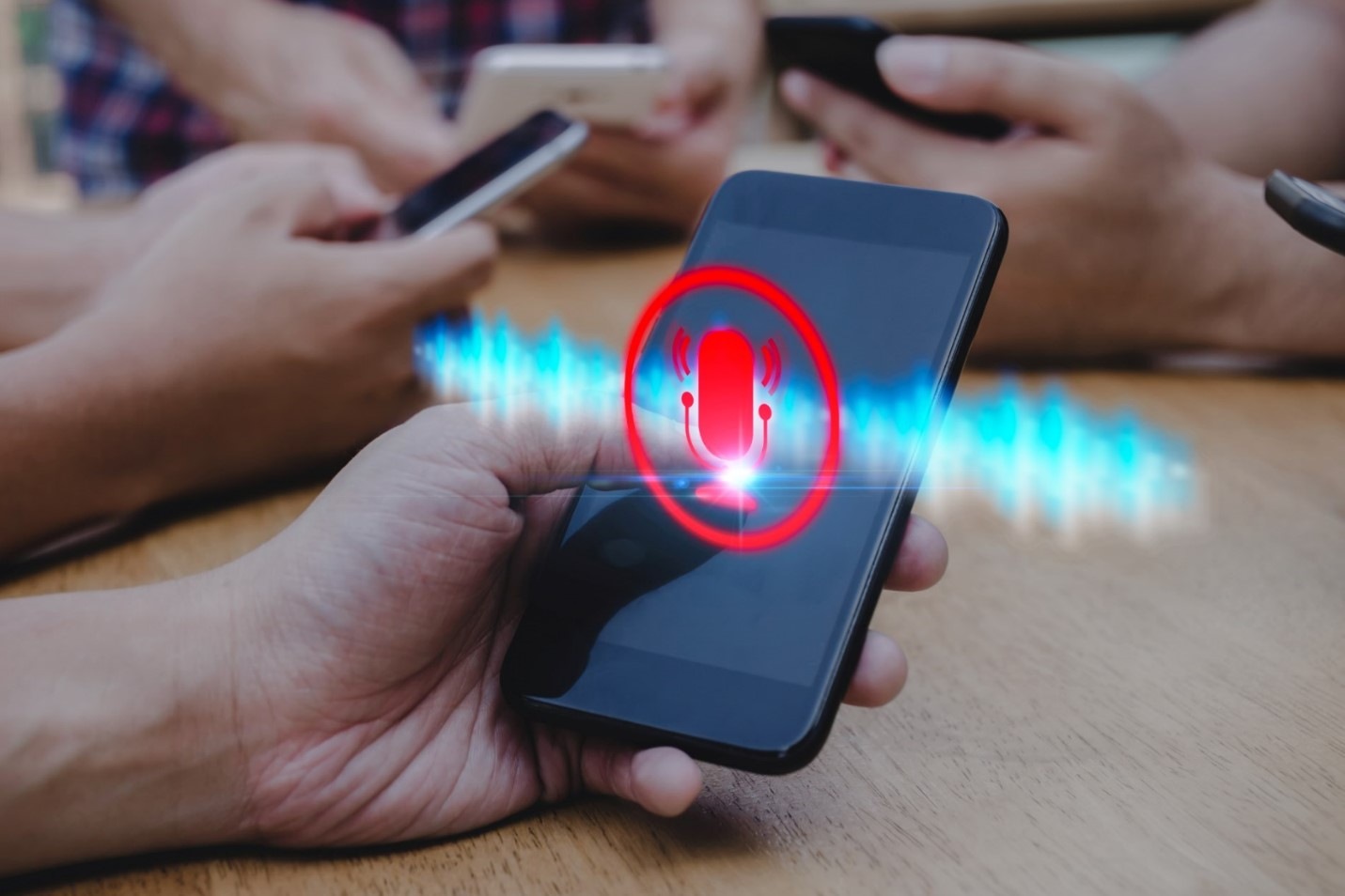 Person holding a smartphone with a speaker icon overlay, representing phone privacy concerns