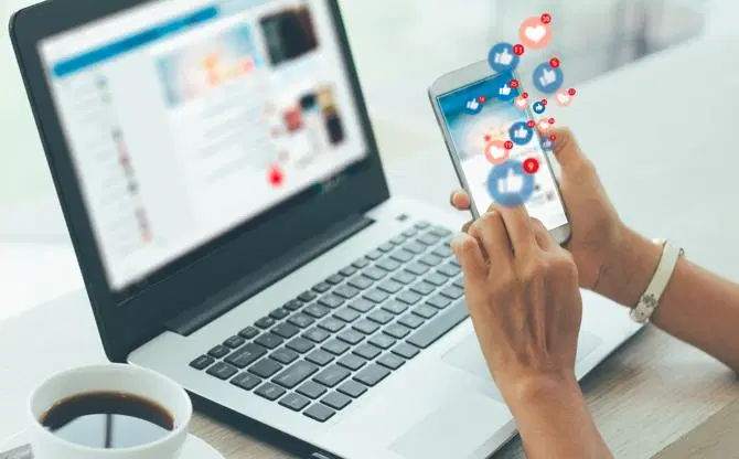 Een gebruiker die zijn privacy op sociale media op zijn telefoon en laptop beschermt.