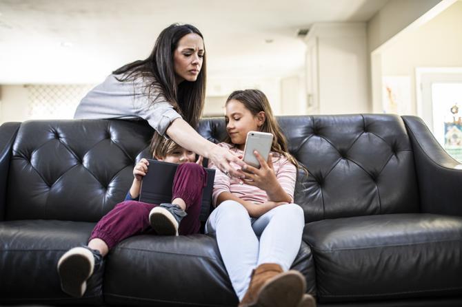 A mother monitoring children using smart devices.