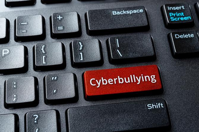 A parent searching the definition of cyberbullying on a computer.