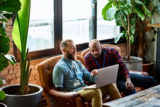 Twee mannen kijken naar een laptop