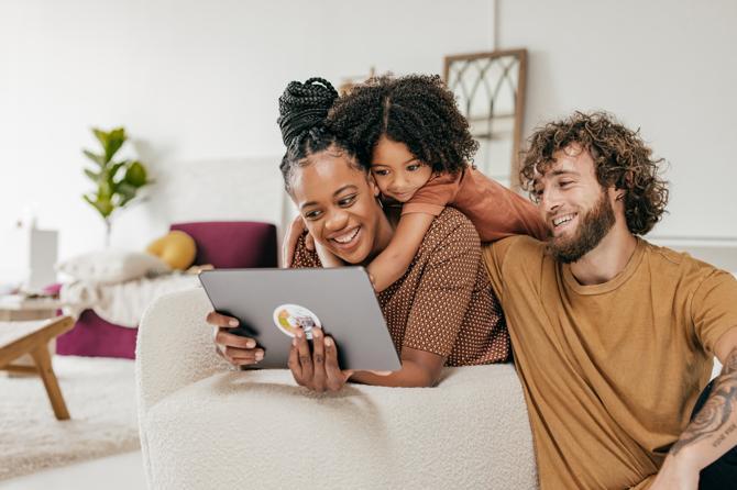 Une femme cherchant des conseils de sécurité en ligne avec son enfant et son partenaire.