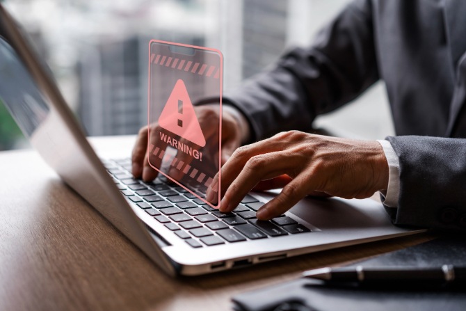 A man on a laptop that’s vulnerable to a malware attack.