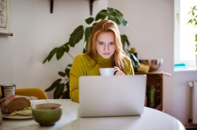 Seorang wanita bekerja menggunakan laptop