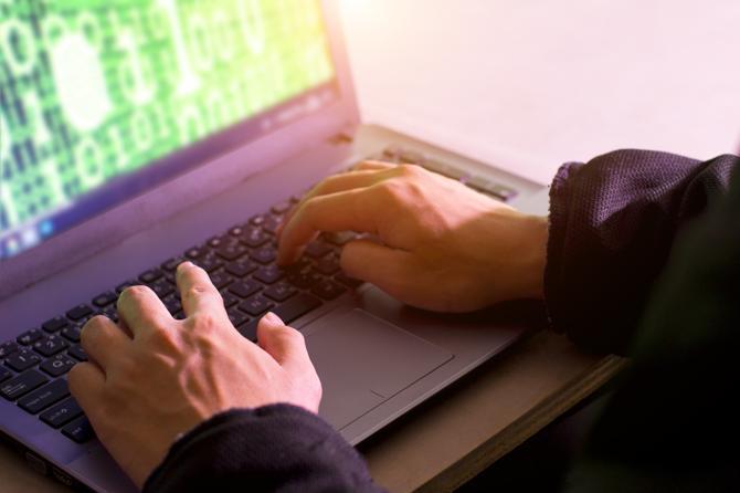 En man med en bärbar dator testar Linux systemsäkerhet.