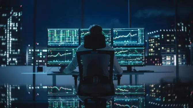 Kryptovaluuttakauppias istuu pöytänsä ääressä”