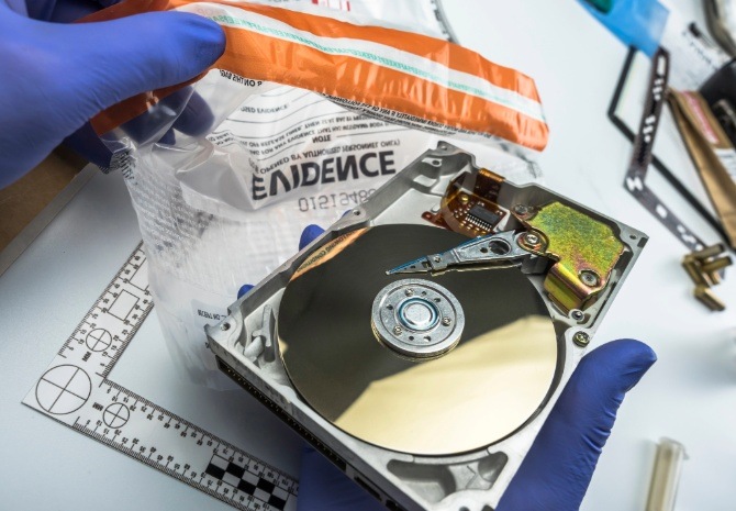 Police expert examining a hard drive during a digital forensics investigation