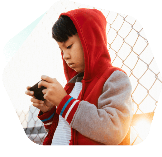 Young boy sitting watching videos on his mobile phone