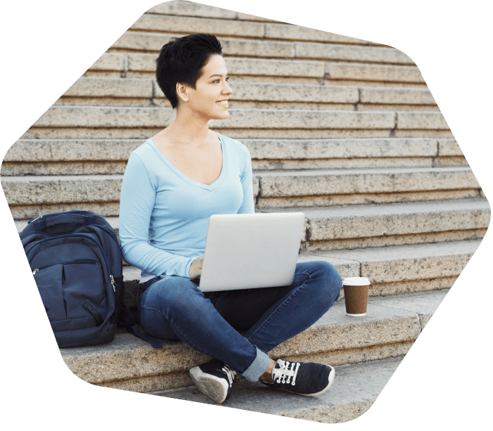 Lady sitting on the steps outside working on her laptop