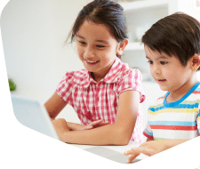 Two young children together looking on their tablet