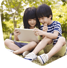 Two young children together looking on their tablet