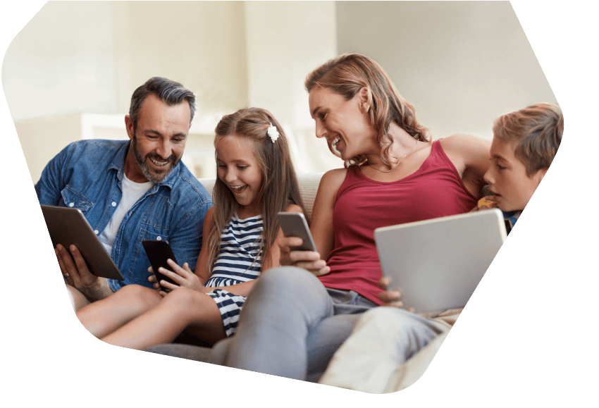 Happy family sitting together all using devices at home
