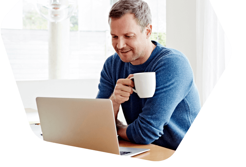 Homem bebendo café enquanto está em seu laptop