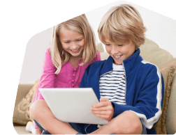 Two young children together looking on their tablet