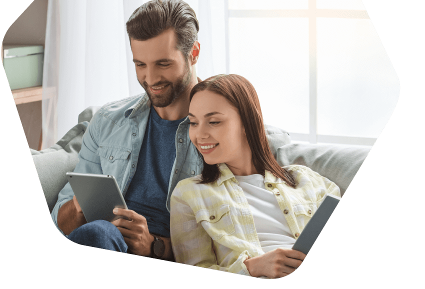 Young couple using their tablets at home
