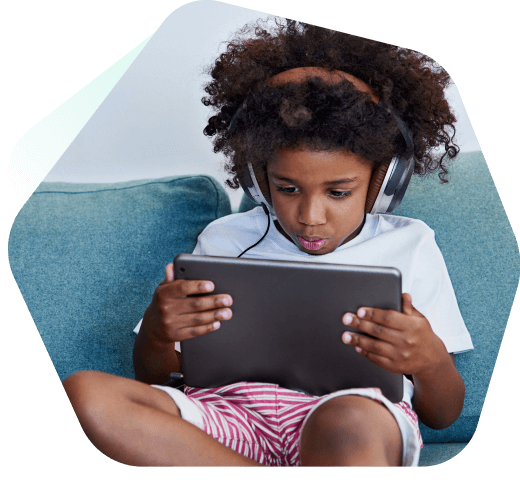 Gutt som ser på YouTube trygt på en bærbar datamaskin ved hjelp av Kaspersky Safe Kids