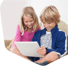 Two young children together looking on their tablet