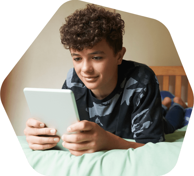 Young boy watching videos on a mobile phone outside